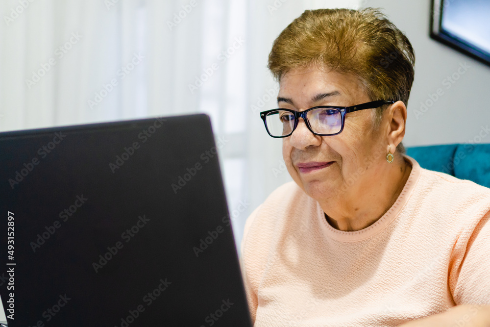 close up of an older latina woman using a laptop computer close up of an older latina woman using a laptop computer