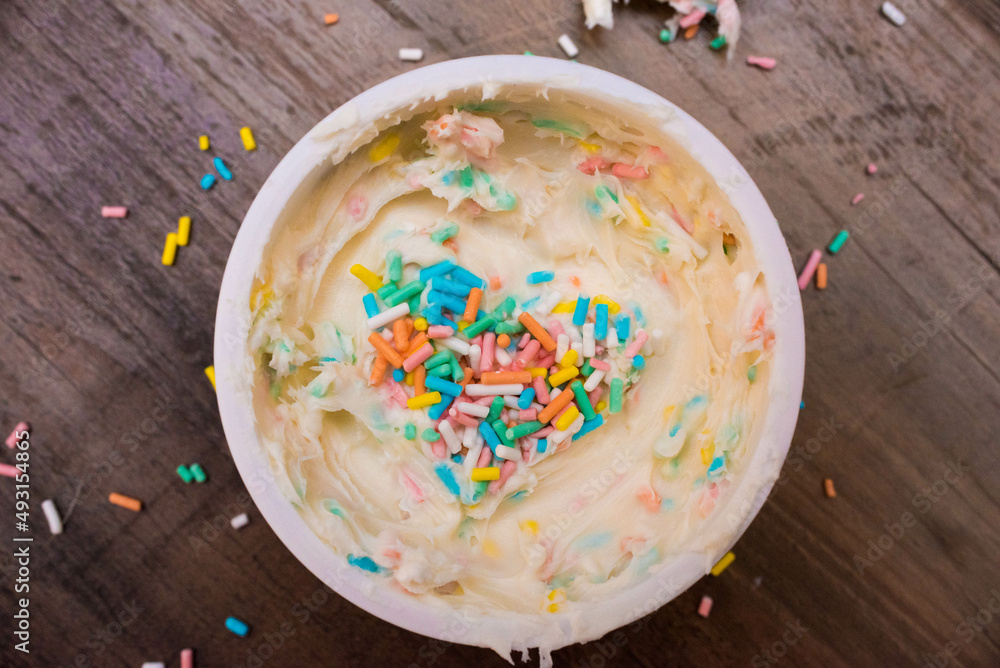 vanilla frosting with pastel sprinkles for spring baking concept vanilla frosting with pastel sprinkles for spring baking concept