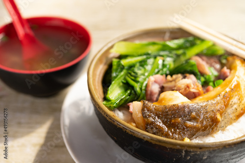 angle view clay pot rice with fish and pickled duck and vegetable
