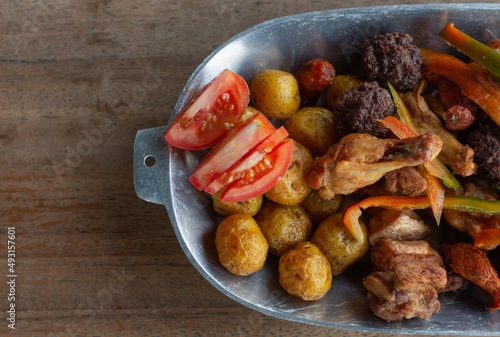 fried or chopped, traditional Colombian food, composed of fried meatballs, chicken, creole potato, pork rinds, banana, lemon and tomato photo