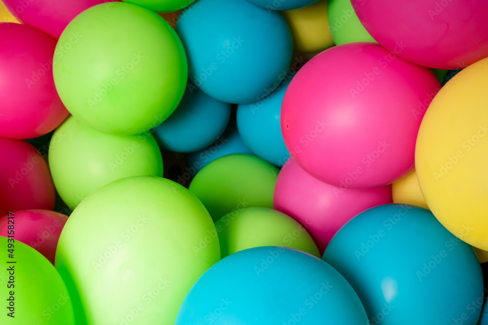 Colorful balloons all over the frame, lying one next to the other. Many colored balloons looking like colored balls Colorful balloons all over the frame, lying one next to the other. Many colored balloons looking like colored balls