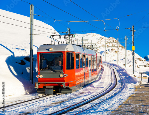 Red swiss train running through the snow