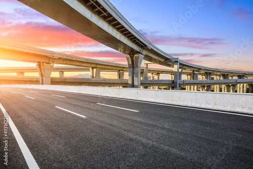 Empty asphalt road and bridge building scenery at sunrise © ABCDstock