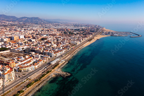Aerial view of coastal town of Premia de Mar on Catalan coast of turquoise Mediterranean Sea with marina on warm winter day, Maresme, Spain © JackF