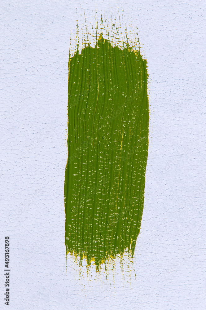 wide brush stroke with saturated bright light olive-green paint on a