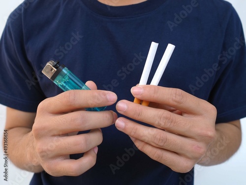 Young man holding a cigarette and matches in his hand.