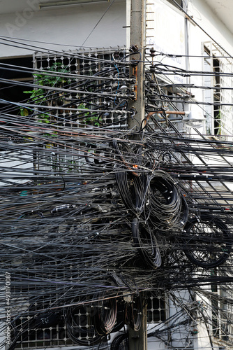 Photography Communications and electric power transmission cables are seen attached to a street pole in the city of Bangkok, Thailand