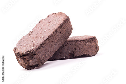 white background. the briquette is dark in color. an alternative type of fuel for heating. close-up. photo