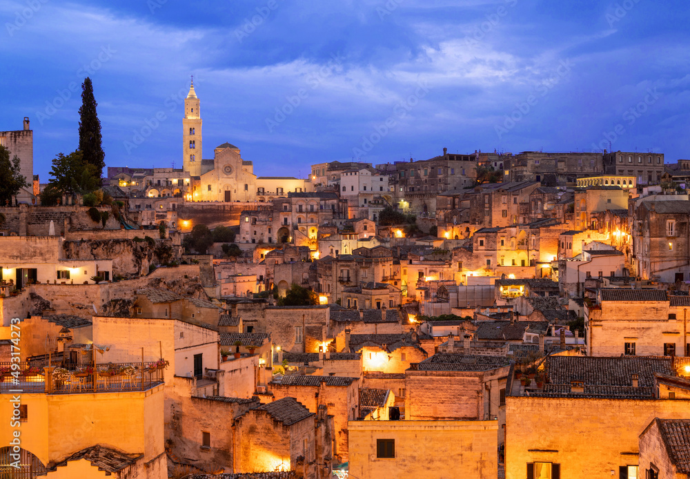 Matera, Basilicata, Italy.August 2021. Cityscape at blue hour with wide angle lens in the direction of the Sassi of Matera. Chaotic arrangement of the houses, in the background the cathedral.