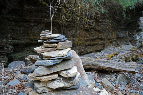 Prayer stone stacks among natural landscape of waterfall cascade and green forest park