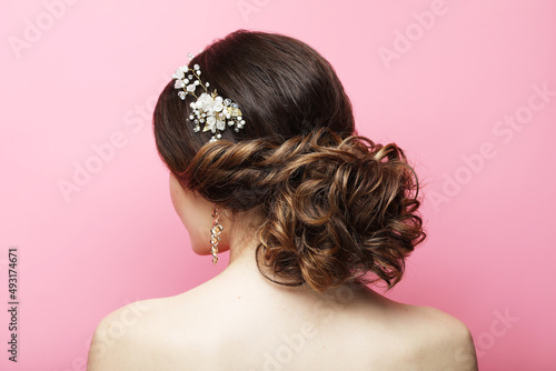 Bride with wedding diadem. Young model with Beautiful Hairstyle over pink background.