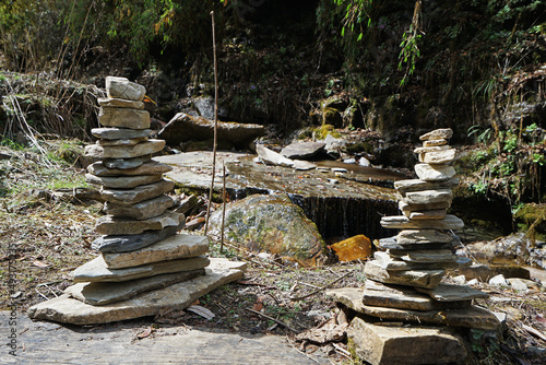 Prayer stone stacks among natural landscape of waterfall cascade and green forest park