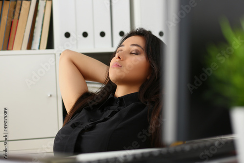 Female office worker having break, napping with closed eyes at work photo