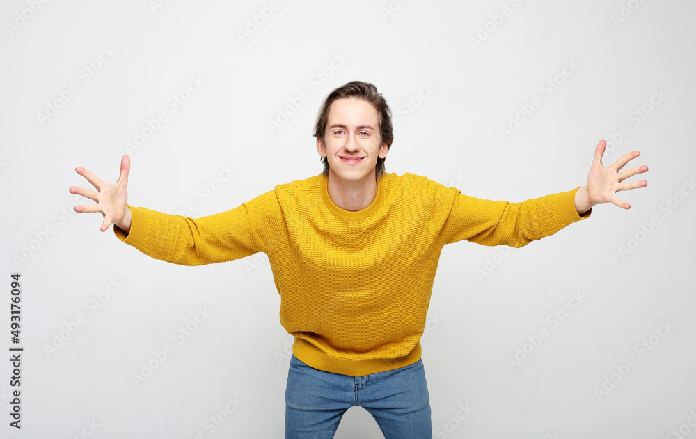 young man wearing yellow sweater very happy and excited doing winner gesture with arms raised young man wearing yellow sweater very happy and excited doing winner gesture with arms raised