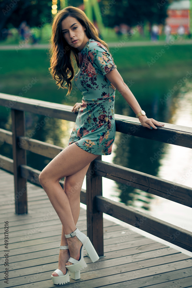 Beautiful young woman outdoors. Romantic model in summer outfit near river or lake.