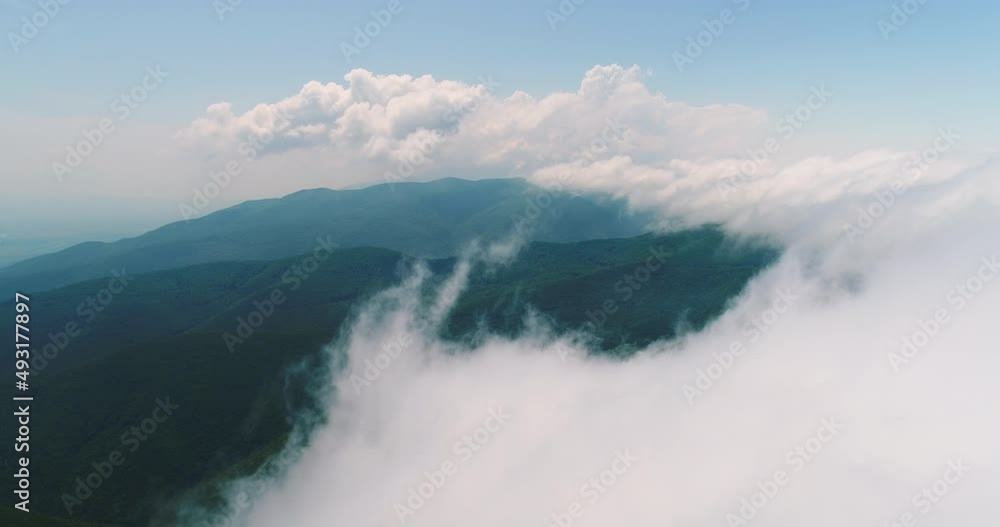 Aerial drone view over the mountain hills with a morning fog and clouds Aerial drone view over the mountain hills with a morning fog and clouds