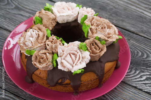 Marble cake with chocolate and marshmallow roses. Close-up.