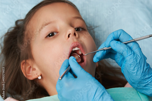 Little girl with open mouth sitting in the dentist's chair