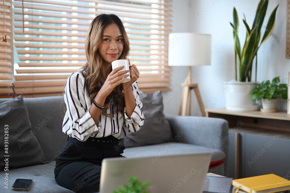 Relaxing beautiful woman sitting on sofa at home and drinking coffee in the morning. Relaxing beautiful woman sitting on sofa at home and drinking coffee in the morning.