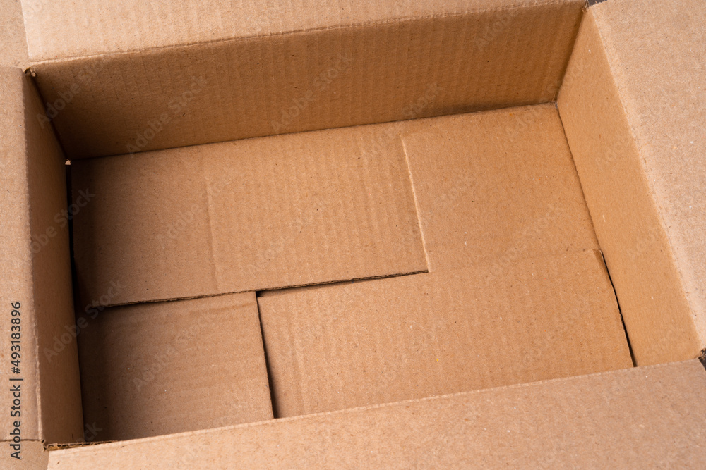 Cardboard box on beige background in studio Cardboard box on beige background in studio