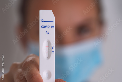 Closeup of woman showing express covid test with positive coronavirus result