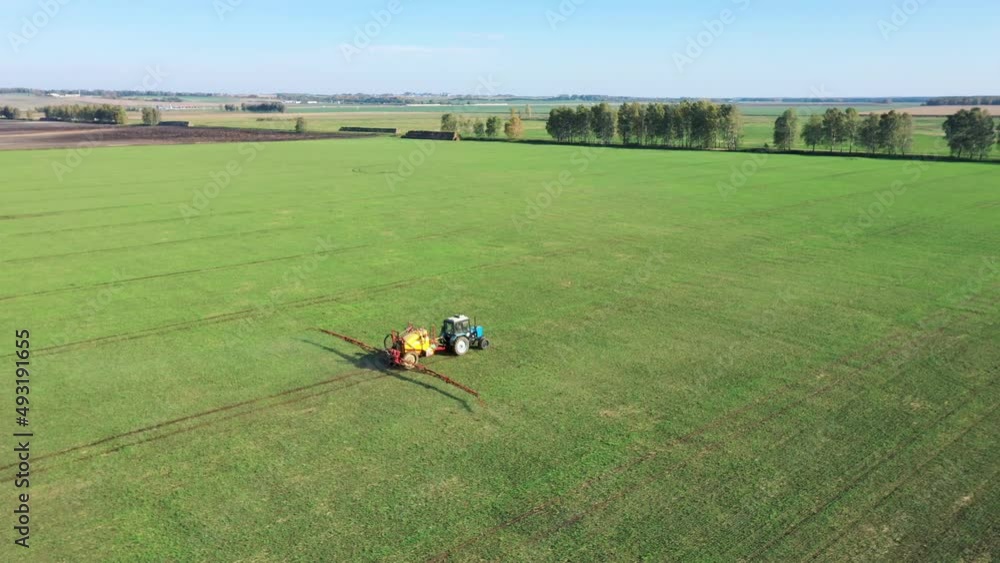 Tractor Spraying Herbicides And Pesticides Fertilizer On Rural Field Tractor Spraying Herbicides And Pesticides Fertilizer On Rural Field