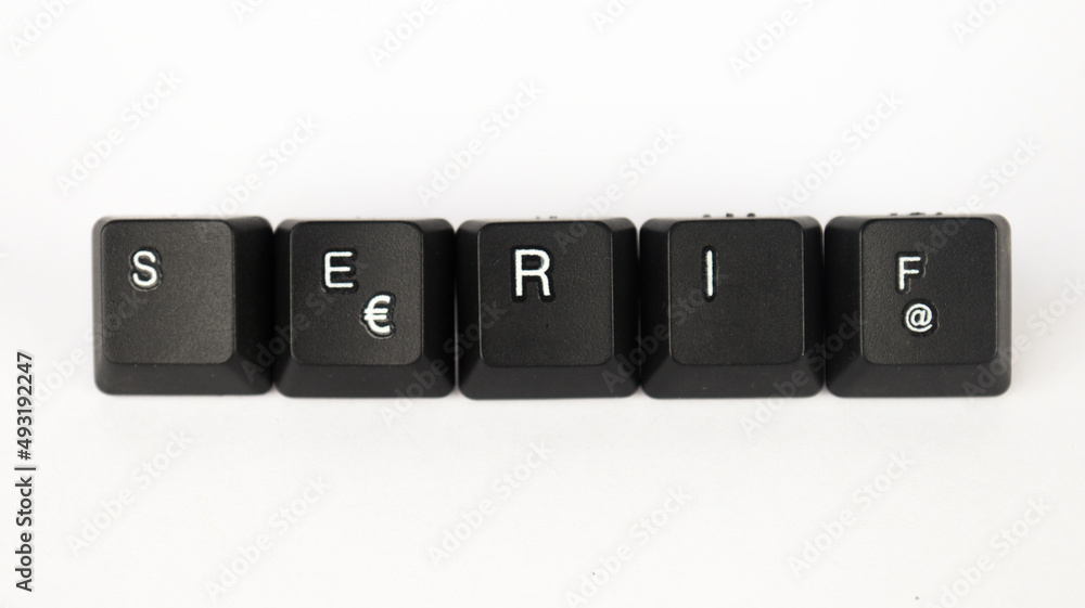 Serif text created with keyboard keys isolated on white background, white serif  font letters on black keyboard, top view