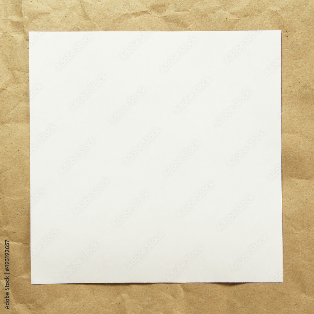 Square white empty sheet of paper on a beige craft paper. Concept of analysis, study, attentive work. Stock photo with empty place for your text and design. Square image shape. Square white empty sheet of paper on a beige craft paper. Concept of analysis, study, attentive work. Stock photo with empty place for your text and design. Square image shape.