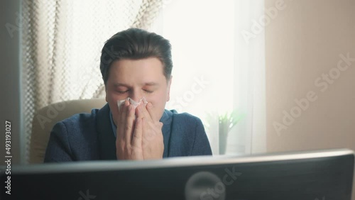 man blowing his nose into a tissue. catarrhal condition photo