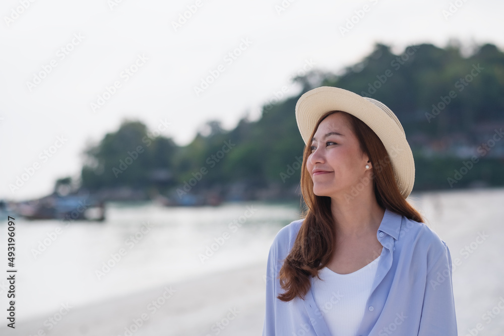 Portrait image of a beautiful young asian woman strolling on the beach