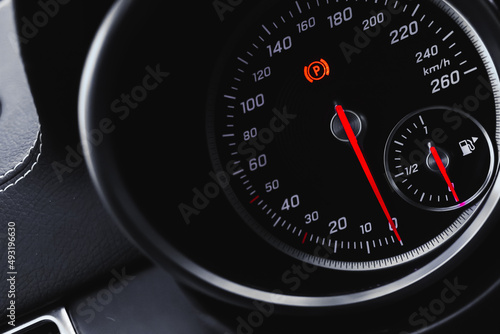 Car speedometer, luxury dashboard with glowing red indicators close-up view, background photo