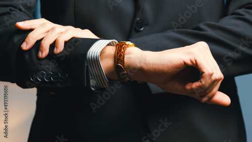 Elegant dressed man checks wristwatch