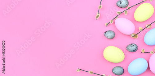 Willow branches and decorations, Easter eggs on a pink background with copy space. Happy easter flat lay