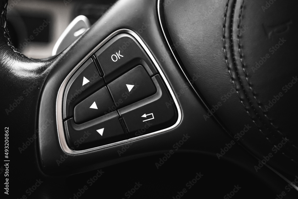 Steering wheel controls button inside luxury car with leather interior. Modern vehicle background photo