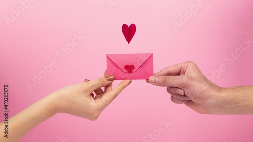 woman giving heart letter on pink background