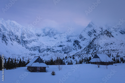 Mountain chalet in the Tatras during the blue hour. Winter mountain landscape with a view of the mountain ridges.