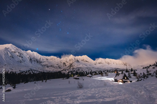 Mountain chalet in the Tatras during the blue hour. Winter mountain landscape with a view of the mountain ridges.