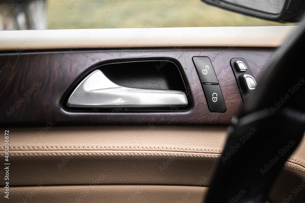 Car door handle with door lock control panel inside luxury car interior with leather Car door handle with door lock control panel inside luxury car interior with leather
