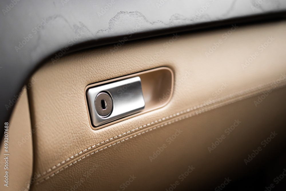 Closed with key glove compartment box in luxury car with leather, close-up interior background Closed with key glove compartment box in luxury car with leather, close-up interior background