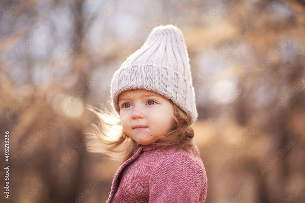 Little beautiful girl portrait in autumn street. Happy smart small girl in autumn park Little beautiful girl portrait in autumn street. Happy smart small girl in autumn park