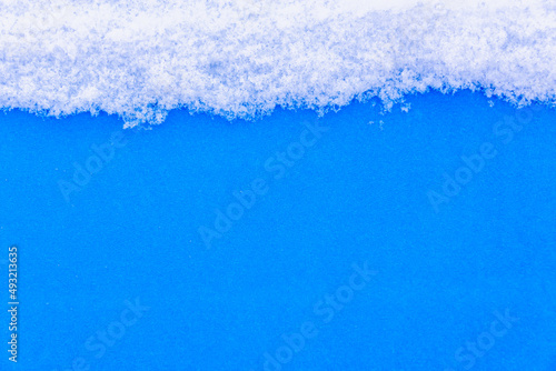 White snow on a blue background (copy space).