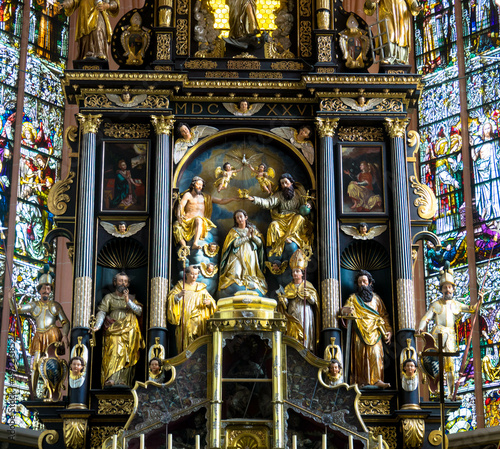 View of the interior of the Basilica St. Michael. A beautiful ornate altar, the walls are decorated with frescoes and images of saints. Mondsee, Upper Austria.