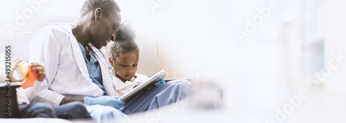 Wallpaper Mural A young African girl is anxiously sitting with the doctor in the examination room looking at the results. Torontodigital.ca