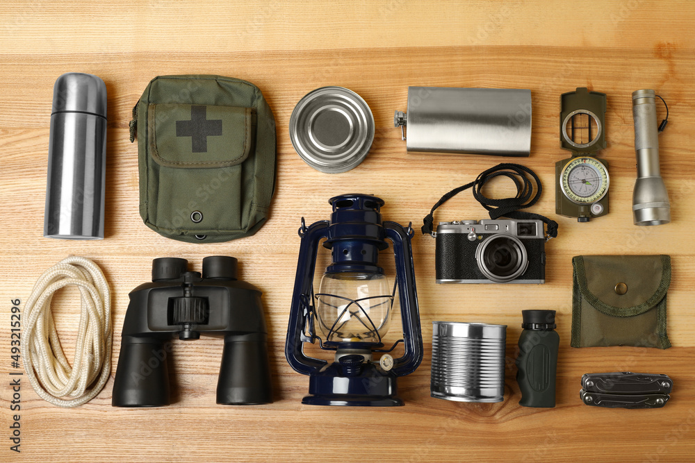 Set of traveler's equipment on wooden table, flat lay Set of traveler's equipment on wooden table, flat lay