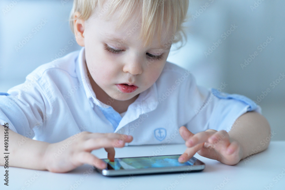 Portrait of boy with smartphone playing the game at home Portrait of boy with smartphone playing the game at home