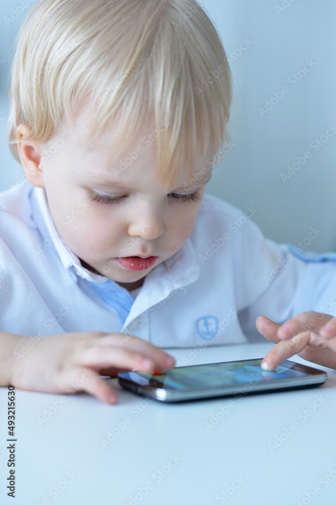 Portrait of boy with smartphone playing the game at home Portrait of boy with smartphone playing the game at home