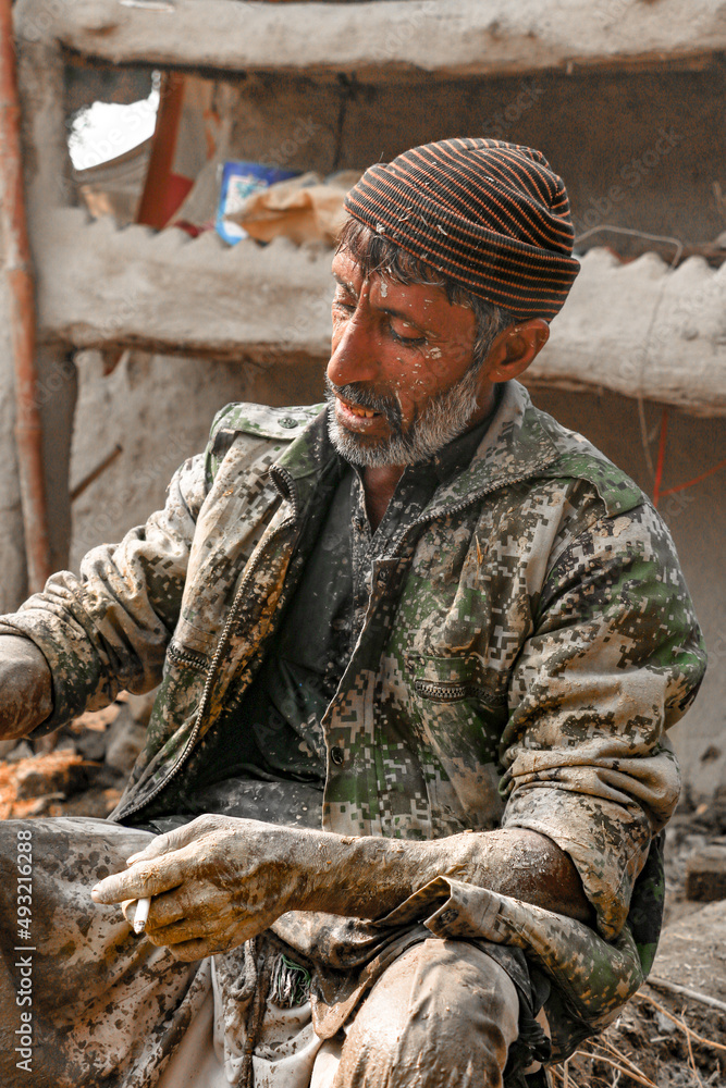 Fototapeta premium old labor worker is tired after hard work he smoking