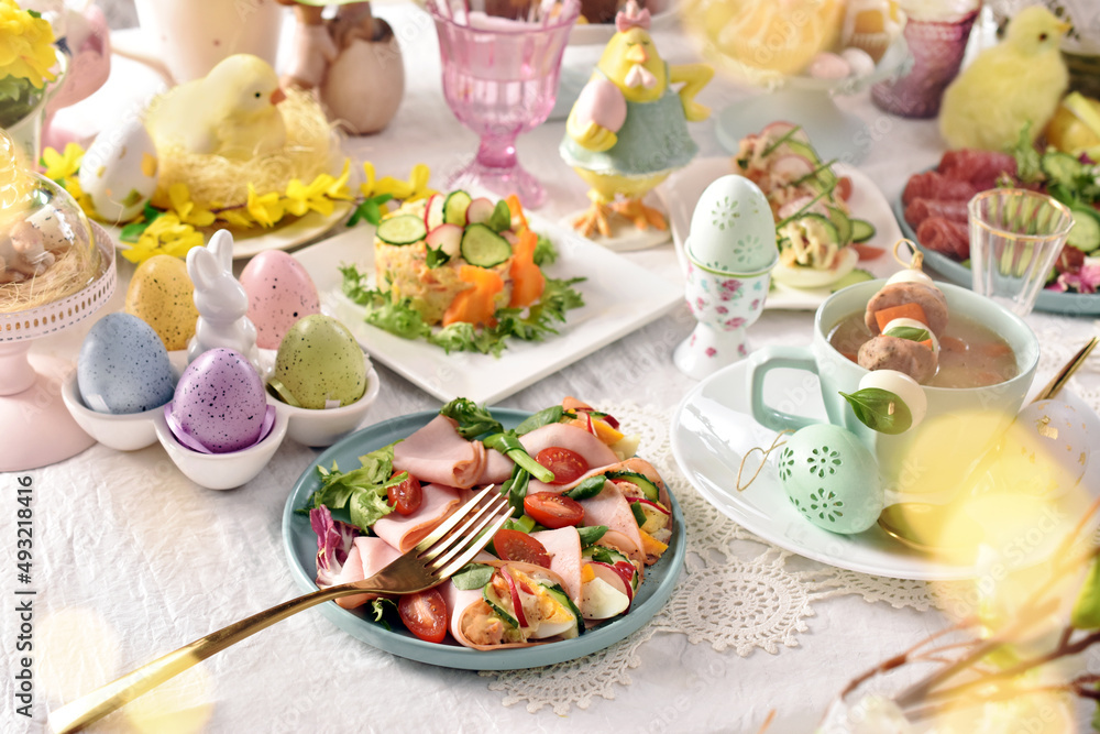 Easter table with salads and white borscht with quail egg and sausage skewer
