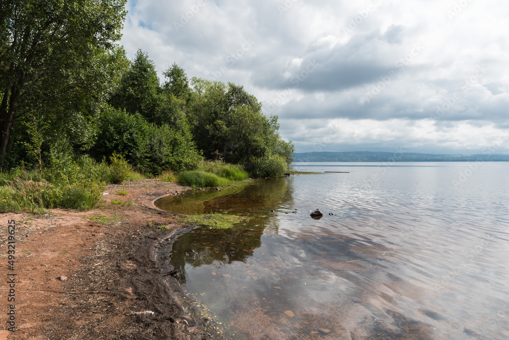 View over a small natural sandy beach at the shore of the Ljusnan river View over a small natural sandy beach at the shore of the Ljusnan river