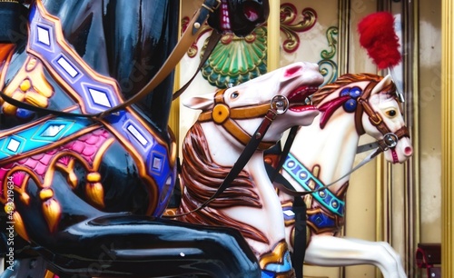Close-up of colorful horses on a traditional vintage merry-go-round ride at a funfair